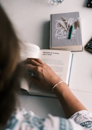 a person sitting at a table with a book and a calculator