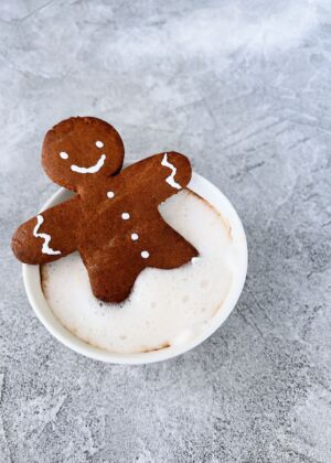 a cup of coffee with a couple of cookies on top of it