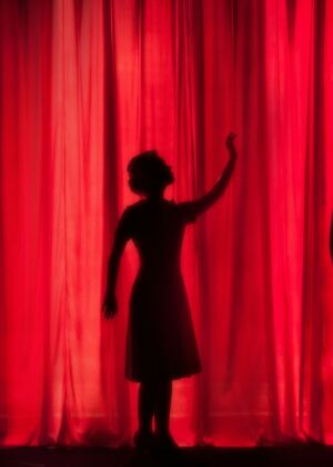 silhouette of three performers on stage