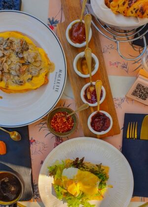 a table topped with plates of food and condiments